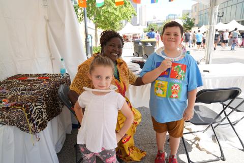 presenter displaying beaded project with kids