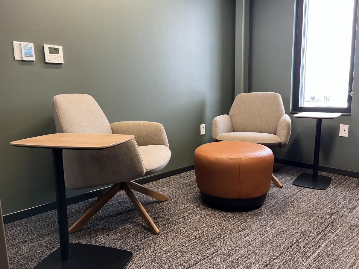 Two comfortable chairs and an ottoman for seating purposes. Two small laptop end tables. 